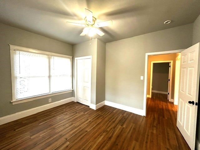 unfurnished room featuring ceiling fan and dark hardwood / wood-style flooring