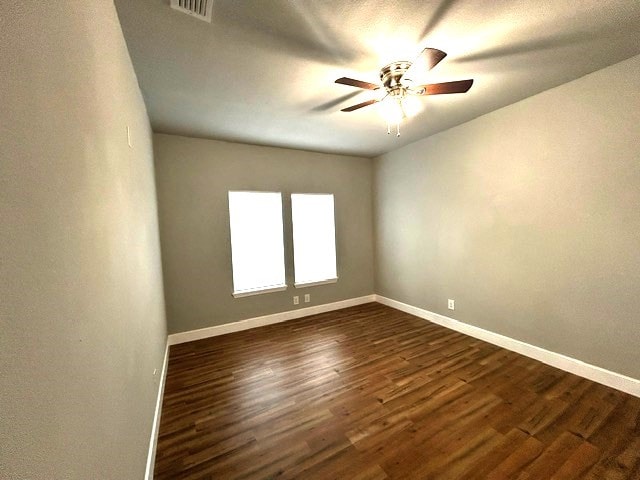 empty room featuring ceiling fan and dark wood-type flooring