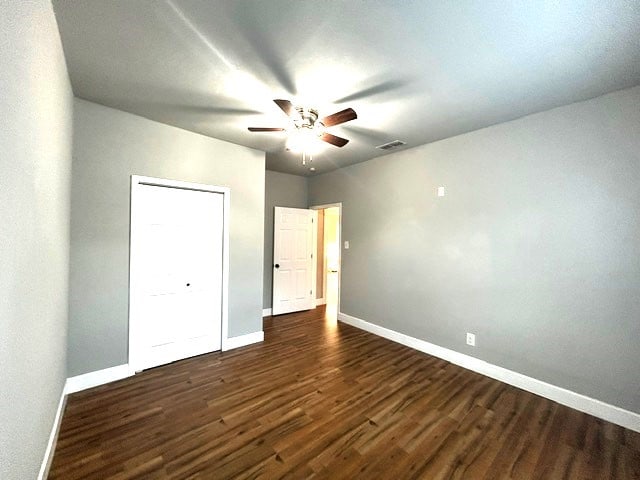 unfurnished bedroom featuring ceiling fan and dark hardwood / wood-style floors