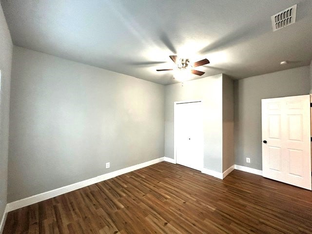 unfurnished bedroom featuring ceiling fan and dark hardwood / wood-style flooring