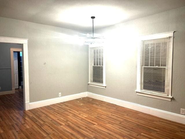 spare room with dark hardwood / wood-style floors and ceiling fan