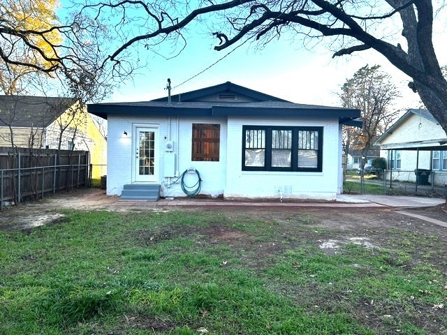 back of house featuring a lawn