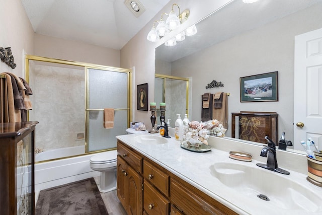 full bathroom with hardwood / wood-style flooring, vanity, bath / shower combo with glass door, and toilet