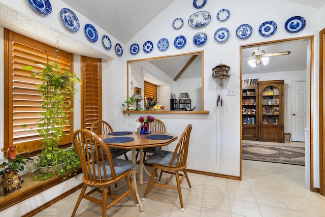 dining room featuring a textured ceiling, ceiling fan, lofted ceiling, and light tile patterned flooring