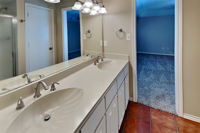 bathroom with a shower with shower door, tile patterned floors, and vanity