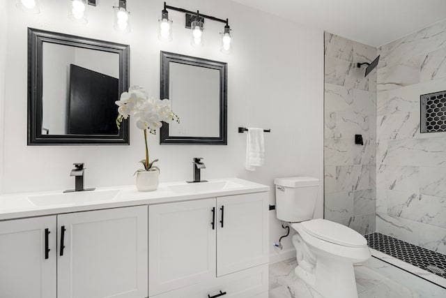 bathroom with a tile shower, vanity, and toilet