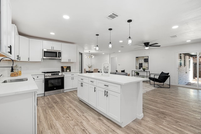 kitchen with white cabinetry, sink, a kitchen island, and appliances with stainless steel finishes