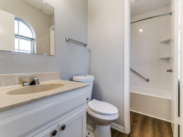 bathroom featuring toilet, vanity, and hardwood / wood-style floors