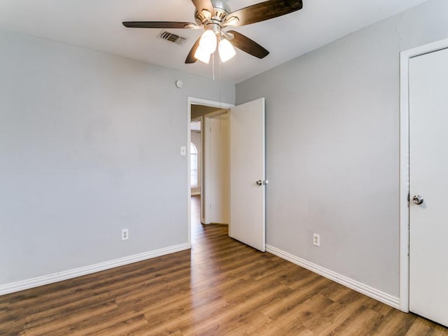 spare room with ceiling fan and dark hardwood / wood-style flooring