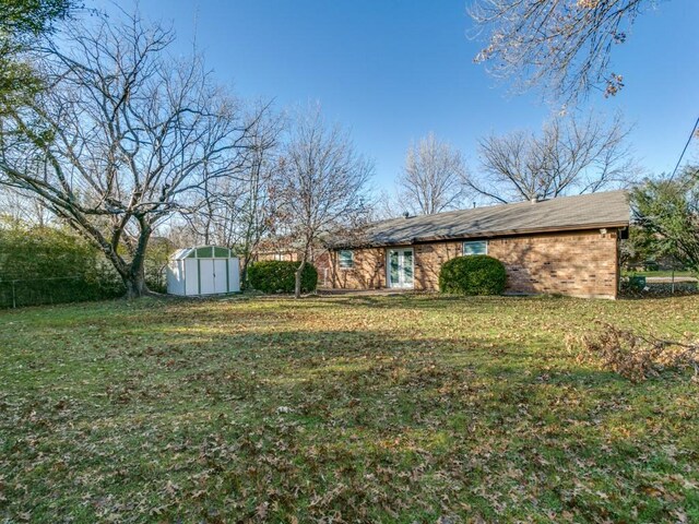 view of front of home with a front yard and a shed