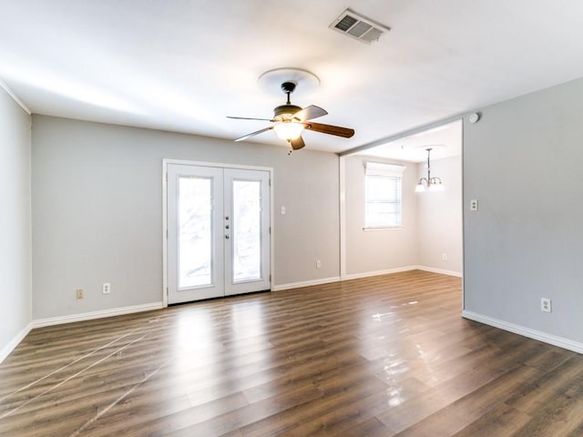 empty room featuring french doors, dark hardwood / wood-style floors, and ceiling fan with notable chandelier