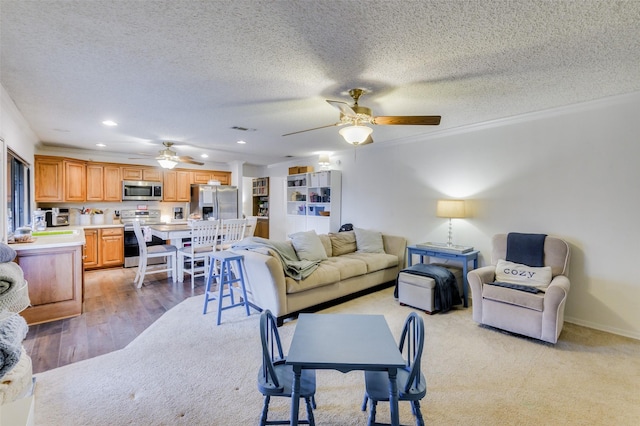 living room featuring crown molding, light hardwood / wood-style floors, and a textured ceiling