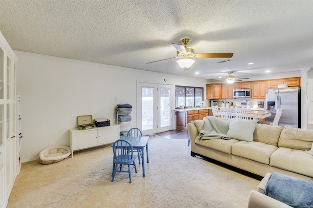 living room with light carpet, french doors, ornamental molding, a textured ceiling, and ceiling fan