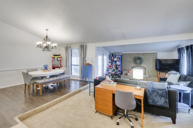 interior space featuring vaulted ceiling, hardwood / wood-style flooring, and an inviting chandelier