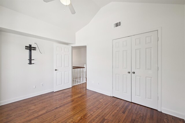 unfurnished bedroom with a closet, vaulted ceiling, ceiling fan, and dark wood-type flooring