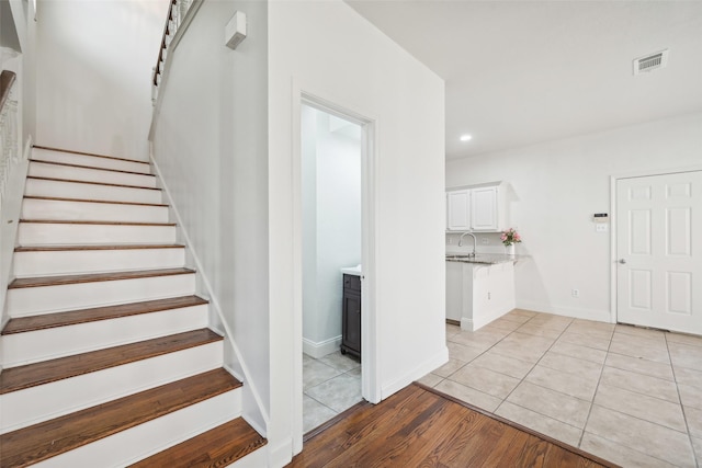 stairway featuring sink and tile patterned floors