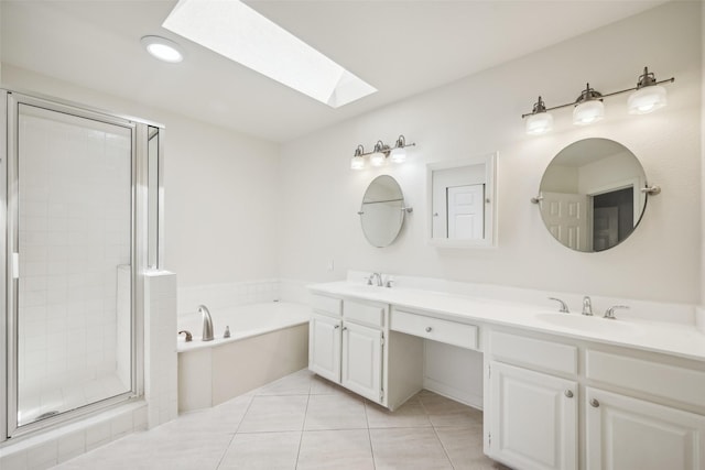 bathroom featuring tile patterned flooring, vanity, a skylight, and plus walk in shower