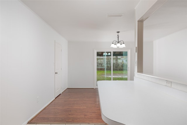 corridor featuring dark hardwood / wood-style floors and a notable chandelier