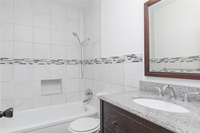 full bathroom with tile walls, vanity, tiled shower / bath combo, and toilet