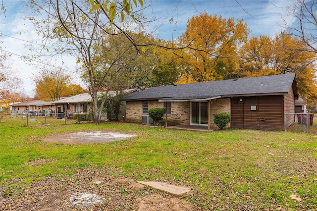 back of property with cooling unit and a lawn