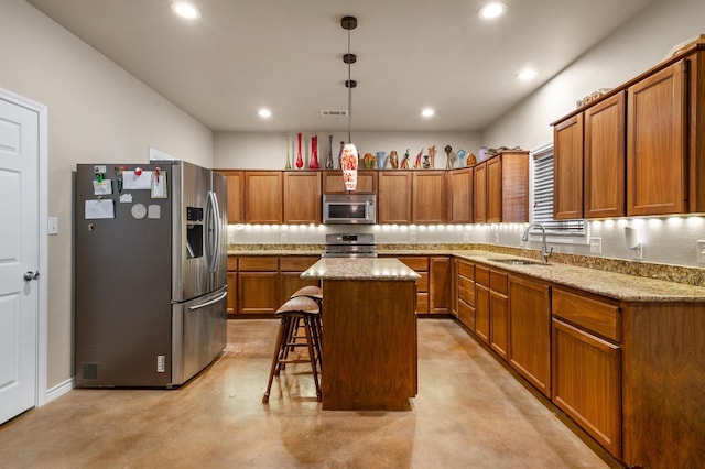 kitchen with a center island, sink, stainless steel appliances, a kitchen breakfast bar, and decorative light fixtures