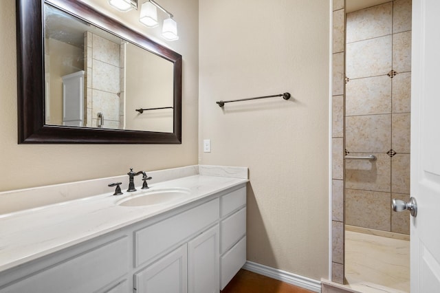 bathroom with vanity and a tile shower