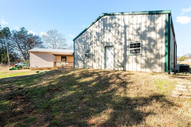 back of property featuring central AC unit and a lawn