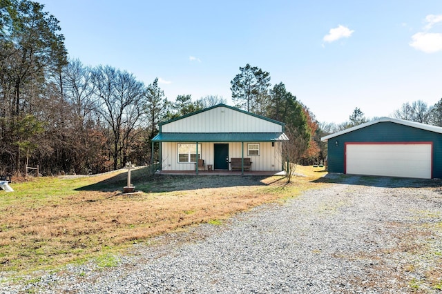 view of front of house featuring an outbuilding, a porch, a garage, and a front lawn