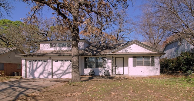 view of front of home with a garage and central air condition unit