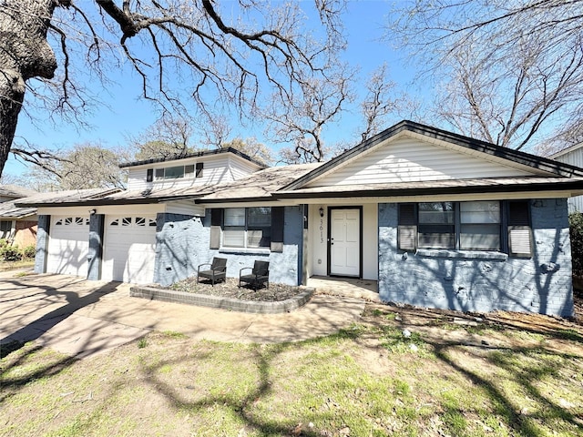 view of front facade featuring an attached garage, concrete driveway, and brick siding