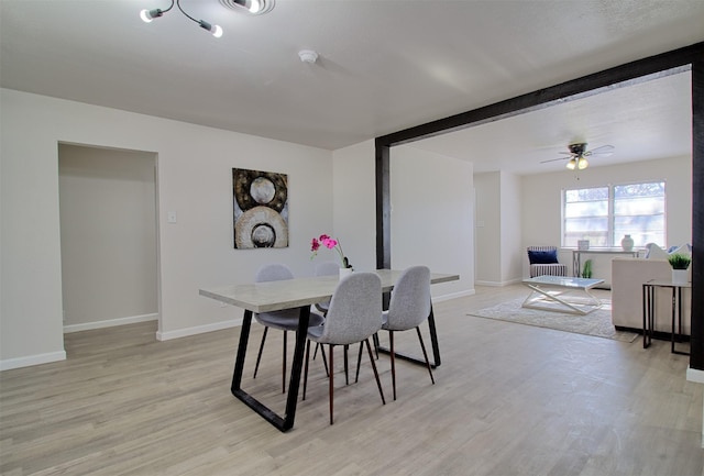 dining area with ceiling fan, beam ceiling, and light wood-type flooring