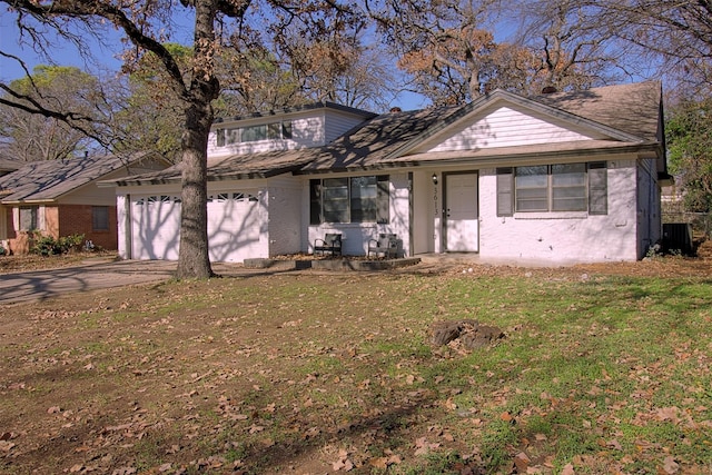 view of front facade featuring central AC unit, a garage, and a front yard