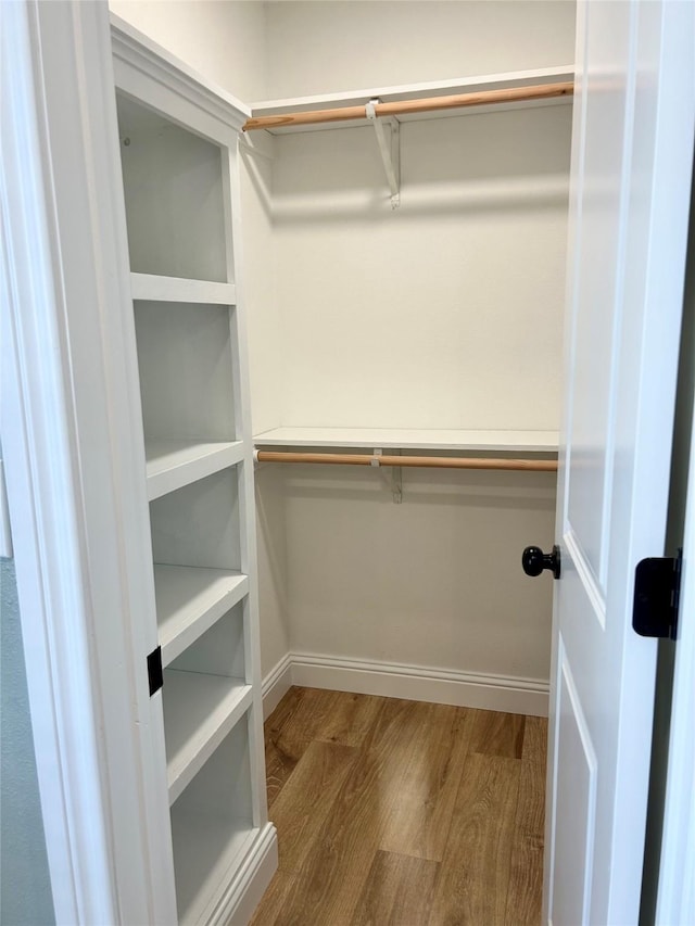 walk in closet with wood-type flooring