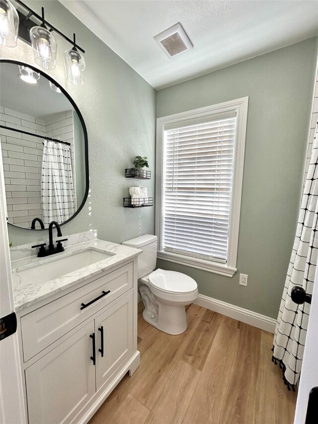 bathroom featuring hardwood / wood-style floors, vanity, toilet, and a shower with curtain