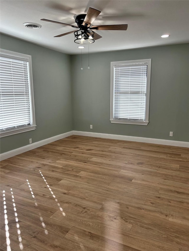 empty room with ceiling fan and hardwood / wood-style floors