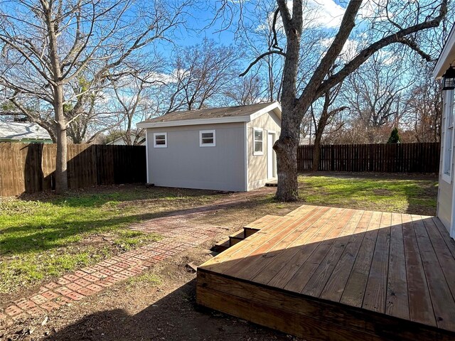 wooden deck with a lawn and a storage unit