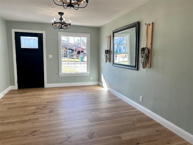 entrance foyer with a chandelier and wood-type flooring