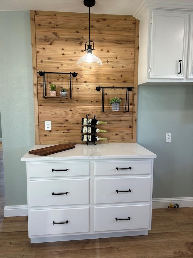 bar featuring white cabinets, pendant lighting, dark hardwood / wood-style flooring, and light stone counters