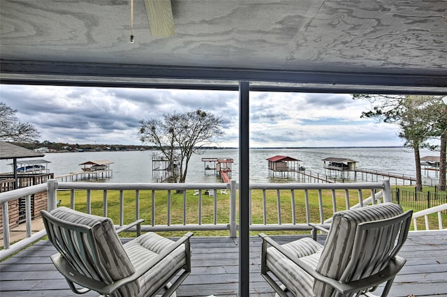 deck featuring ceiling fan, a dock, and a water view