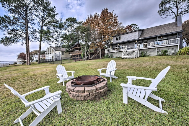 view of yard featuring a deck and an outdoor fire pit