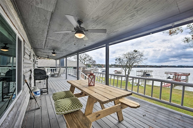 deck with a lawn, a grill, and a water view