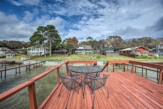 deck with a yard and a water view