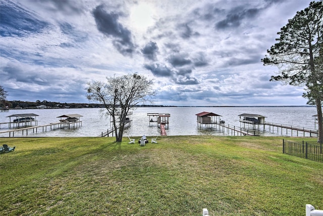 view of dock with a yard and a water view