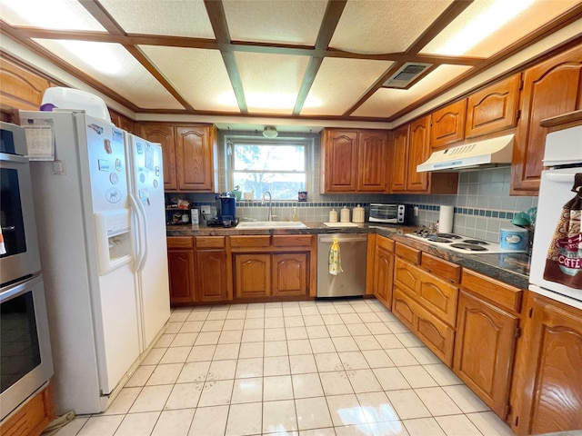 kitchen featuring stainless steel appliances, sink, light tile patterned floors, and backsplash