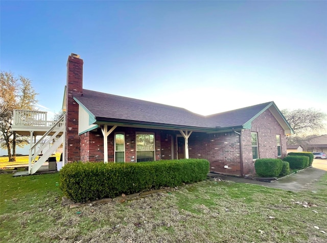 view of front of property featuring a front yard and a deck