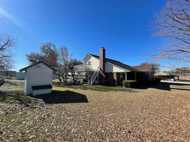 view of property exterior featuring a storage shed, a deck, and a yard