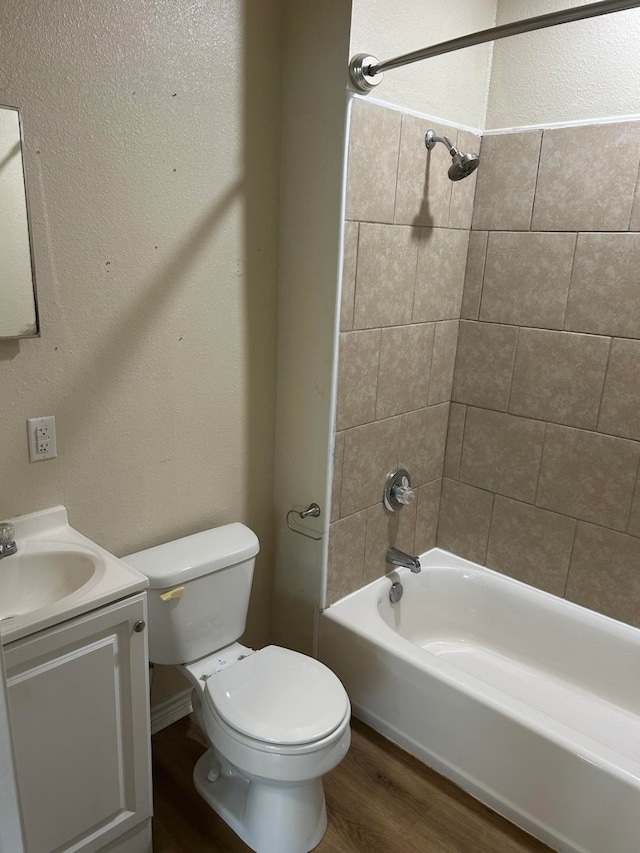 full bathroom featuring vanity, hardwood / wood-style flooring, toilet, and tiled shower / bath