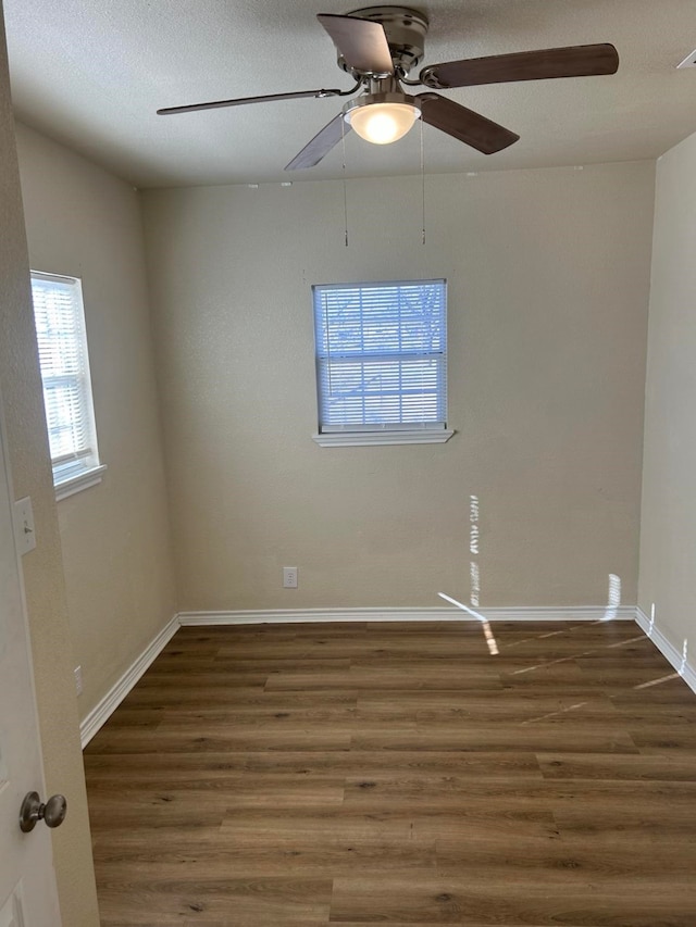 unfurnished room with a textured ceiling, dark hardwood / wood-style flooring, and ceiling fan