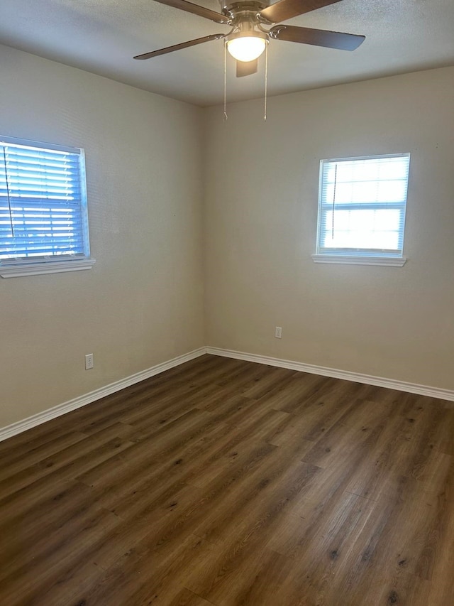 unfurnished room with ceiling fan and dark hardwood / wood-style flooring