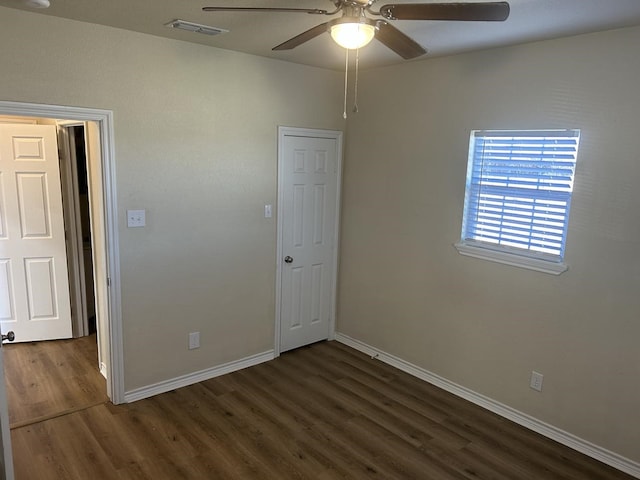 spare room with ceiling fan and dark hardwood / wood-style flooring